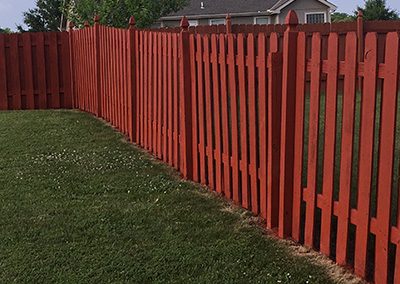 Fence painting project of a red painting wooden fence.