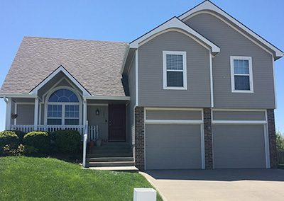 Exterior painting project image of local house with tan and red paint.