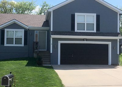 Exterior painting project image of local house with blue and white paint.