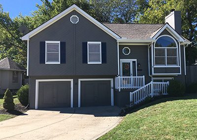 Exterior painting project image of local house with grey and blue paint.