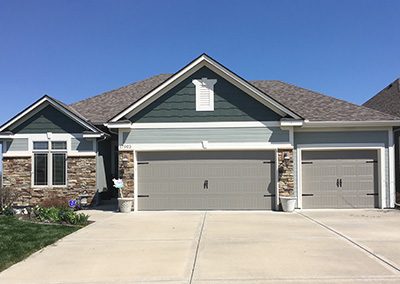 Exterior painting project image of local house with green and grey paint.