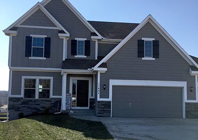 Exterior painting project image of local house with brown and maroon paint.