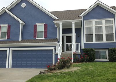 Exterior painting project image of local house with blue and maroon paint.