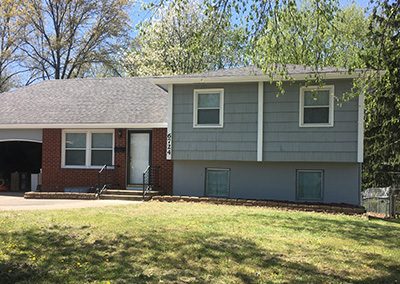 Exterior painting project image of local house with green and white paint.